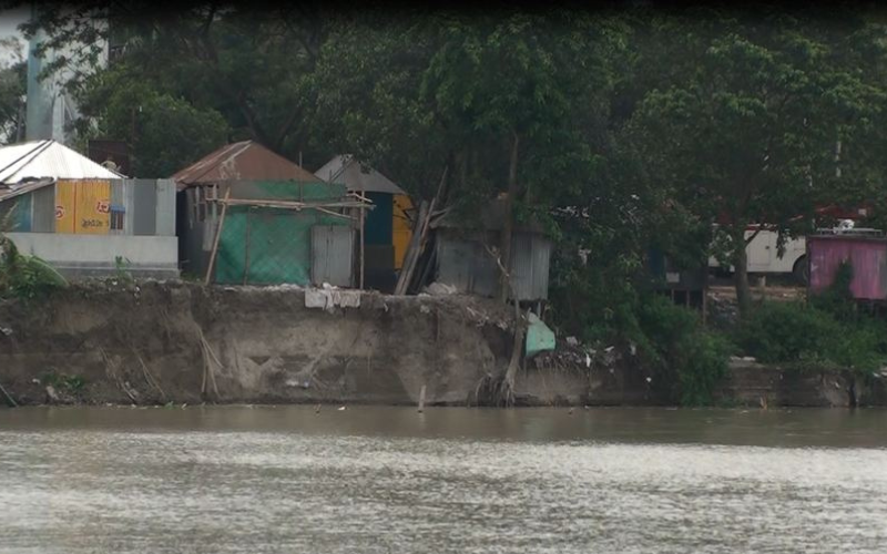নদীর পাড়ে ঝুঁকিপূর্ণভাবে দাঁড়িয়ে থাকা ভাঙনকবলিত বসতভিটা ও ঘরবাড়ি