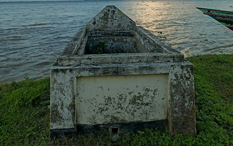 নদীভাঙনের কিনারায় অরক্ষিত অবস্থায় পড়ে থাকা একটি পুরোনো কবর